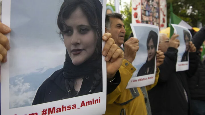 Lidé v Berlíně drží na demonstraci 20. září 2022 fotografii Íránky Mahsá Amíníové, která zemřela poté, co ji zadržela mravnostní policie. 