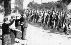 Sudetští Němci na podzim roku 1938 nadšeně zdraví jednotky německého Freikorpsu.