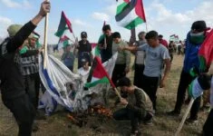 Palestinci pálí vlajku Izraele.