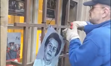 Pracovník ze sídla komunistů odstraňuje portrét oběti komunistů  (FB Covidens, screenshot)