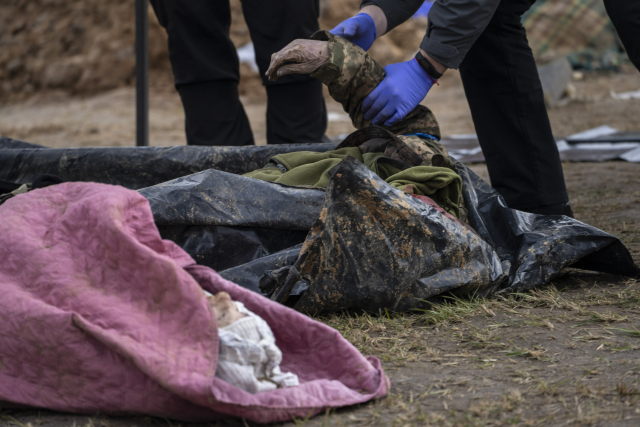 Mrtvola vytažená z masového hrobu v ukrajinské Buči (ČTK/AP/Rodrigo Abd)