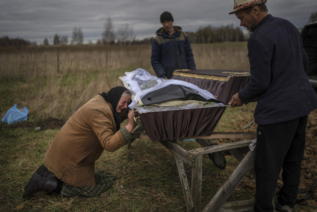 Nadiya (70) u hrobu svého syna (†48), který zahynul v Buči (ČTK/AP/Rodrigo Abd)