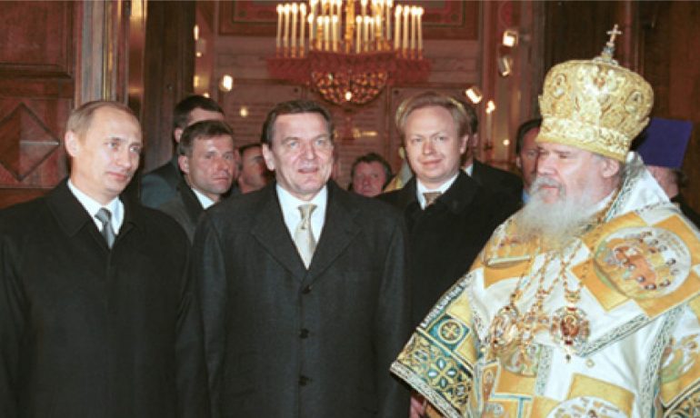 Prezident Putin, německý spolkový kancléř Gerhard Schröder a patriarcha moskevský a celé Rusi Alexij II. před vánoční bohoslužbou. (commons.wikimedia.org/CC BY 4.0/Kremlin.ru)