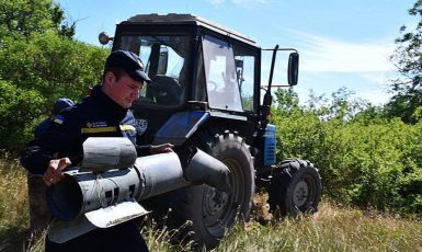 Příslušník Státní pohotovostní služby Ukrajiny odnáší  nevybuchlou ruskou bombu z pole na Ukrajině (State Emergency Service of Ukraine / Wikimedia Commons /CC BY-SA 4.0)
