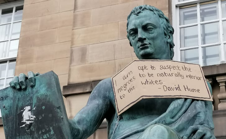 Socha Davida Humea v Edinburghu, 
na kterou aktivisté pověsili ceduli s úryvkem Humeovy „rasistické“ poznámky pod čarou.  (Kontexty / Se souhlasem)