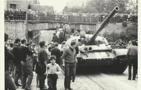 Lidé pozorují postupující armádu vojsk Varšavské smlouvy.