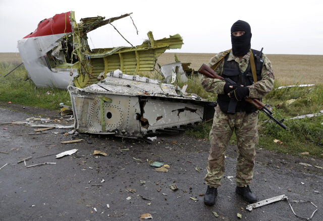 Ilustrační foto (Proruský ozbrojenec poblíž místa katastrofy hlídá trosky letadla před příjezdem pozorovatelů OBSE.)