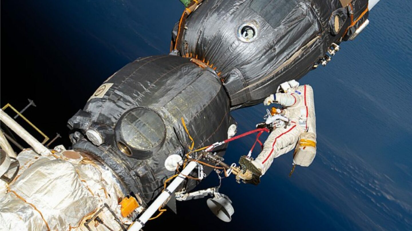 Ruský kosmonaut Oleg Kononěnko kontroluje povrch kosmické lodě Sojuz MS-09.