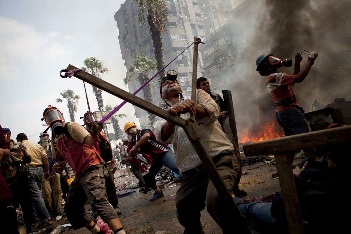 Egypt, 14. srpna 2013 – Přívrženci sesazeného prezidenta Muhammada Mursího se připravují k útoku pomocí improvizovaného praku. Bezpečnostní síly se mezitím pokoušejí vyklidit jejich protestní tábor u mešity Rábaa al-Adavíja na periferii Káhiry.