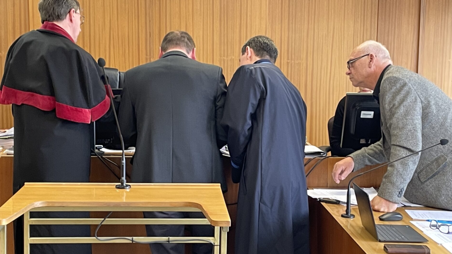 Soud v případu otrávené řeky Bečvy. Státní zástupce, obžalovaný a obhájce nahlížejí na nákres, který pořídil svědek.