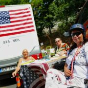 Karavan, osobní auto, stolek, židličky, archy s peticemi, vlajky Spojených států a NATO. Tohle všechno se ve středu 21. června objevilo u chodníku naproti sídlu české vlády. 