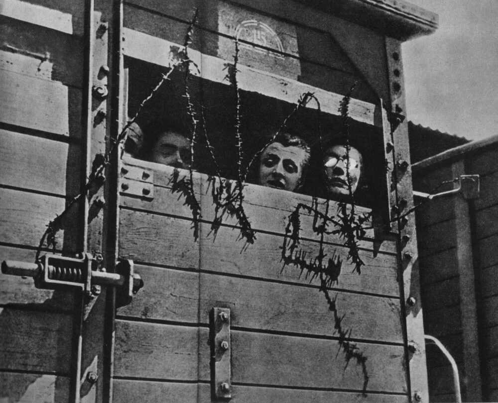 Židé v nákladním vagónu na cestě do tábora smrti.