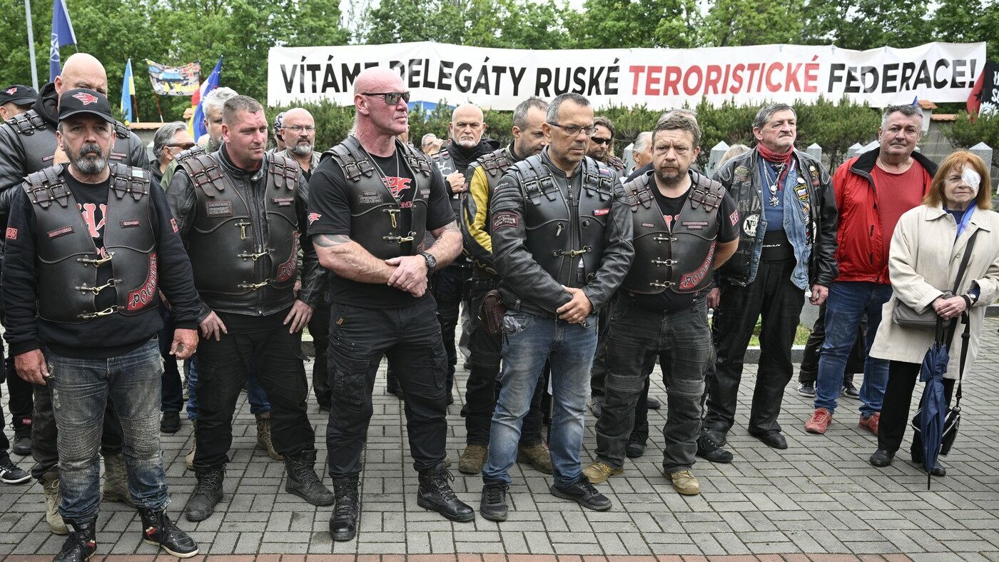 Při příjezdu na příznivce proputinovské motorkářské skupiny Noční vlci čekaly asi tři desítky odpůrců (v pozadí) s vlajkami Evropské unie, NATO, Spojených států nebo Ukrajiny.
